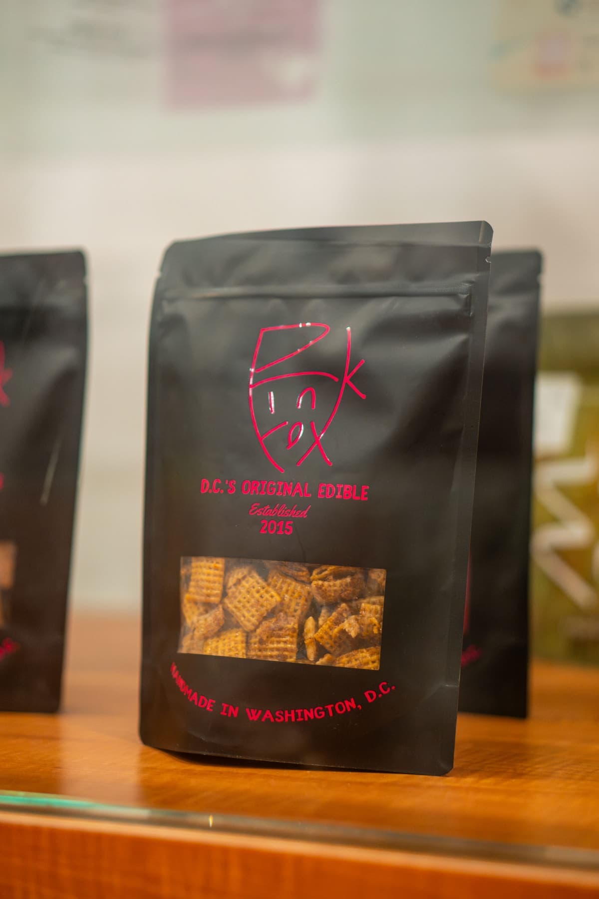 Locally made edibles in black pouches on the shelf