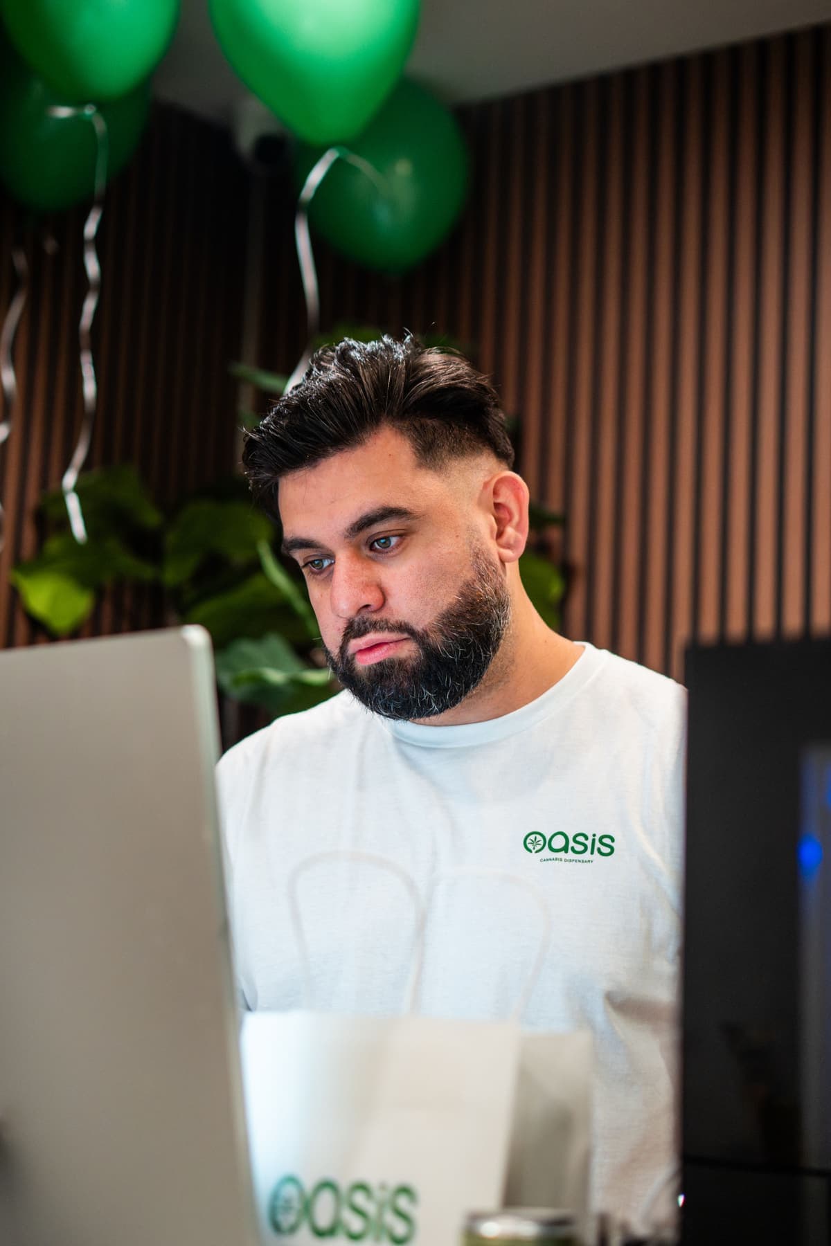 An Oasis team member checking an order on the laptop at the counter